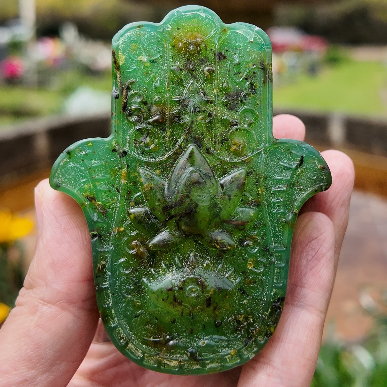 Jabón artesanal Baño de 7 Hierbas Amargas, de color verde y con forma de mano de Fátima, presentado junto a su caja de Conexión Enigma Store.