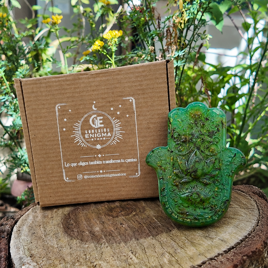 Jabón artesanal Baño de 7 Hierbas Amargas, de color verde y con forma de mano de Fátima, presentado junto a su caja de Conexión Enigma Store.