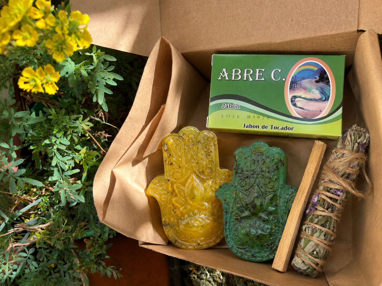 Kit Ritual Renacer con jabón de siete hierbas dulces, jabón de siete hierbas amargas, sahumo de salvia, palo santo y jabón de tocador de obsequio, presentado junto a su caja de Conexión Enigma Store.