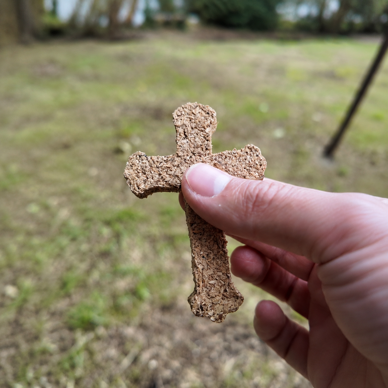Incienso de cruz de palo santo para quemar, elaborado en forma de cruz y presentado sobre una superficie de madera con elementos naturales.